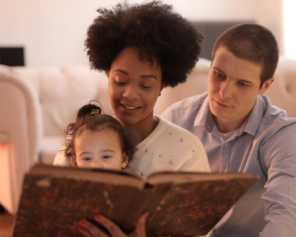 parents reading a book to a toddler