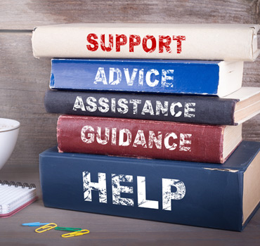Stack of books with the bindings saying Support, Advice, Assistance, Guidance, Help