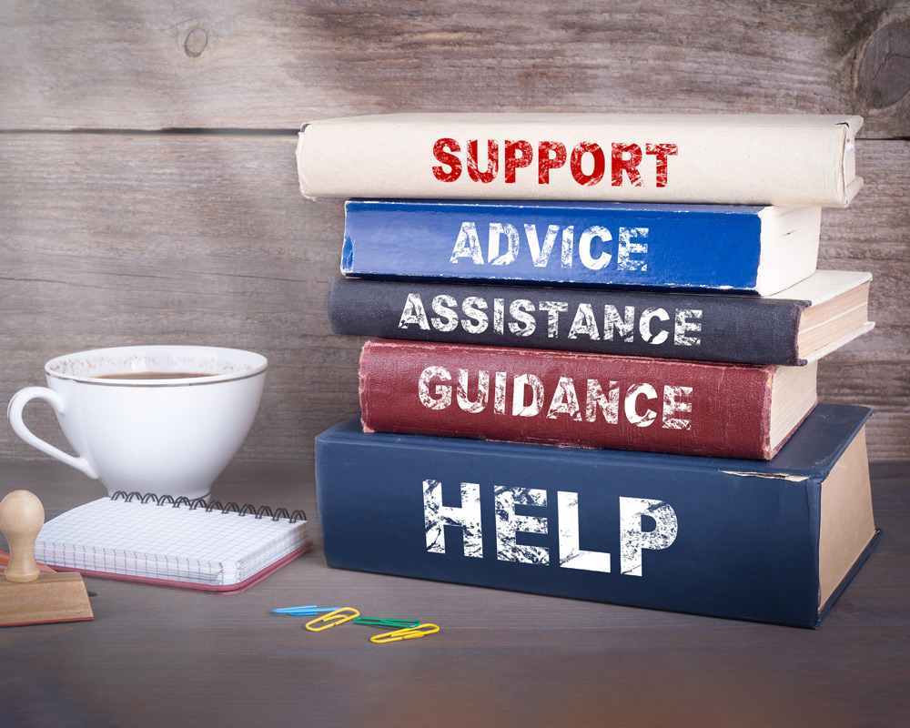 Stack of books with the bindings saying Support, Advice, Assistance, Guidance, Help