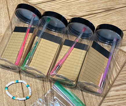 4 jars with notepads and pens inside