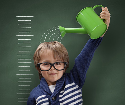 Young boy holding up a watering can
