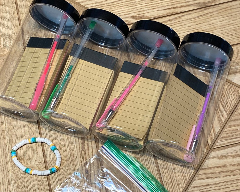 4 jars with notepads and pens inside